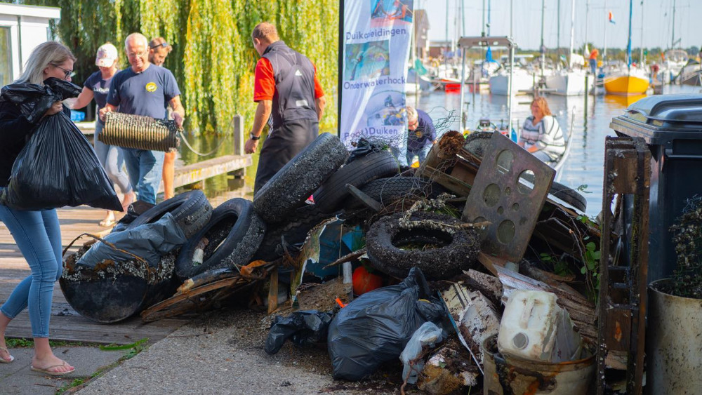 Gooise duikers maken bodem plas schoon en halen berg troep boven water