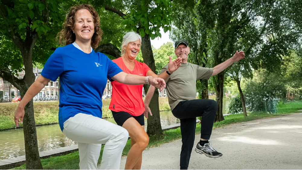 Buurtsportcoach in beweging met 2 senioren