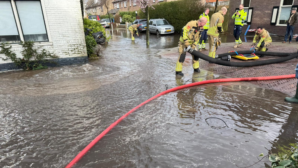 De brandweer pompt het water af.