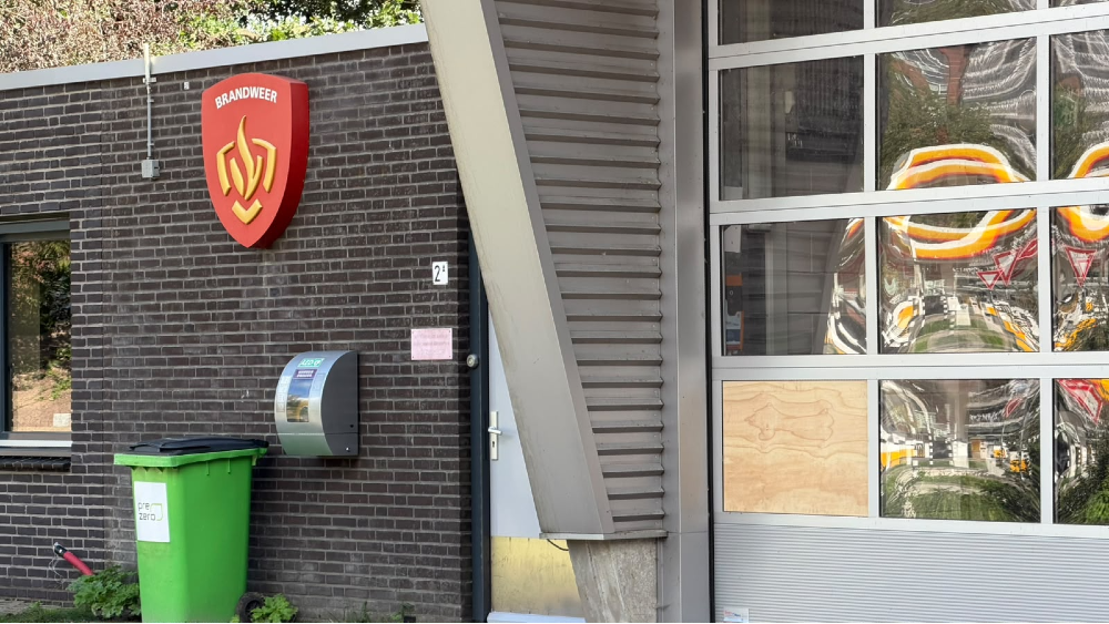 De deur van de kazerne. Een houten plaat is zichtbaar.