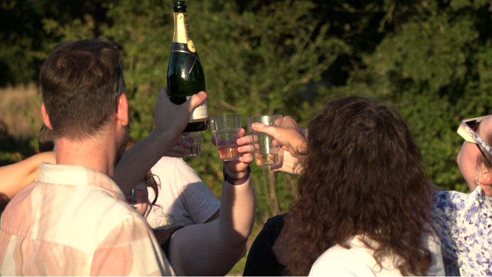 Een groep mensen ontkurkt hun champagne fles