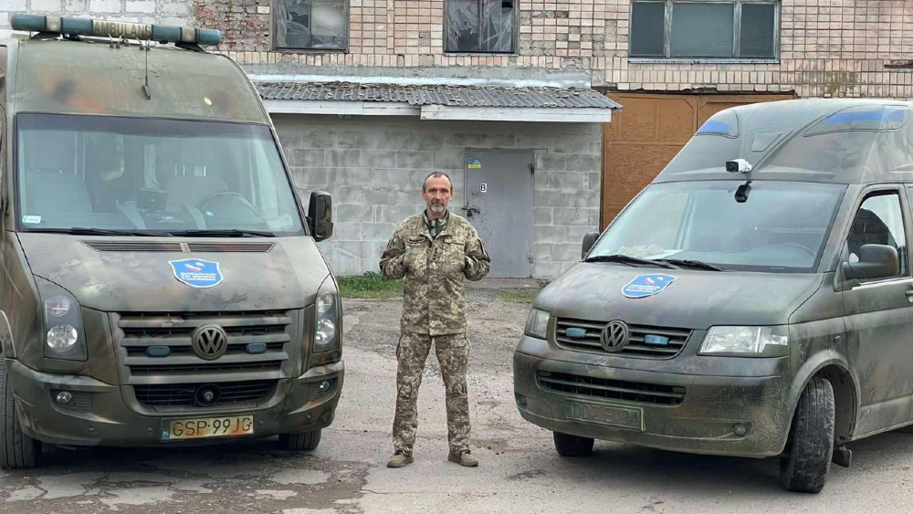 Een soldaat tussen twee groene frontambulances