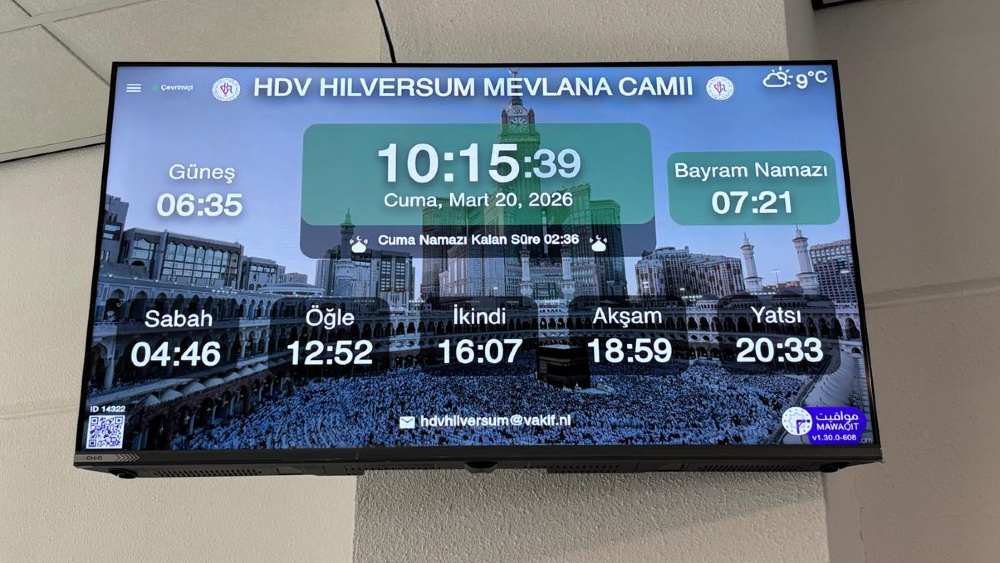 Een televisiescherm met informatie hangt in de moskee. Rechtsmidden staat de tijd voor het ramadangebed.