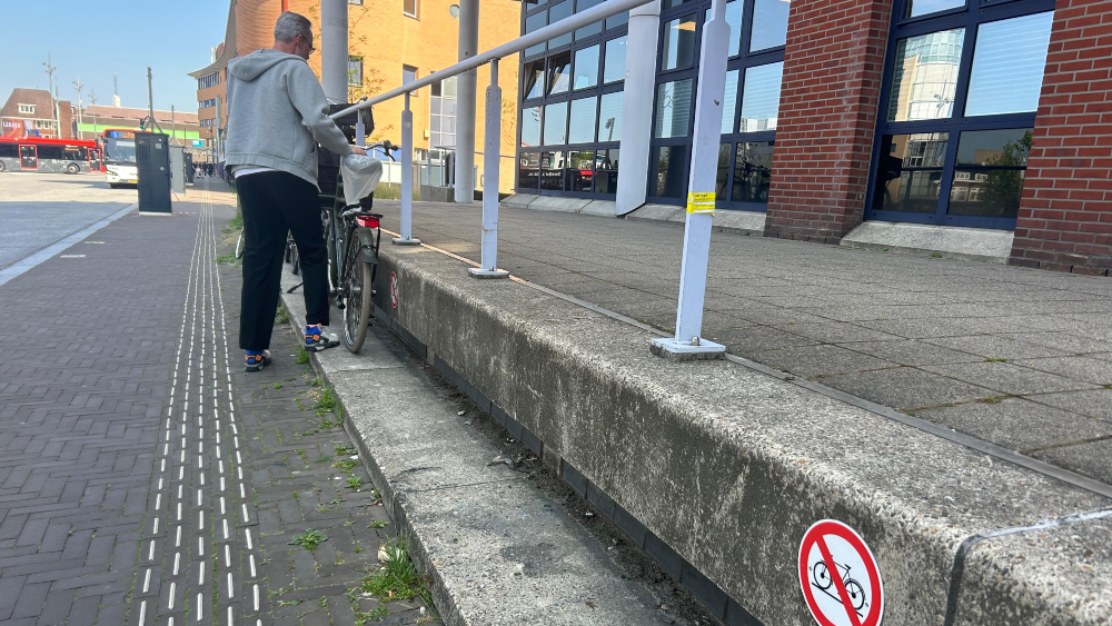 Man parkeert fiets voor het Sociaal Plein